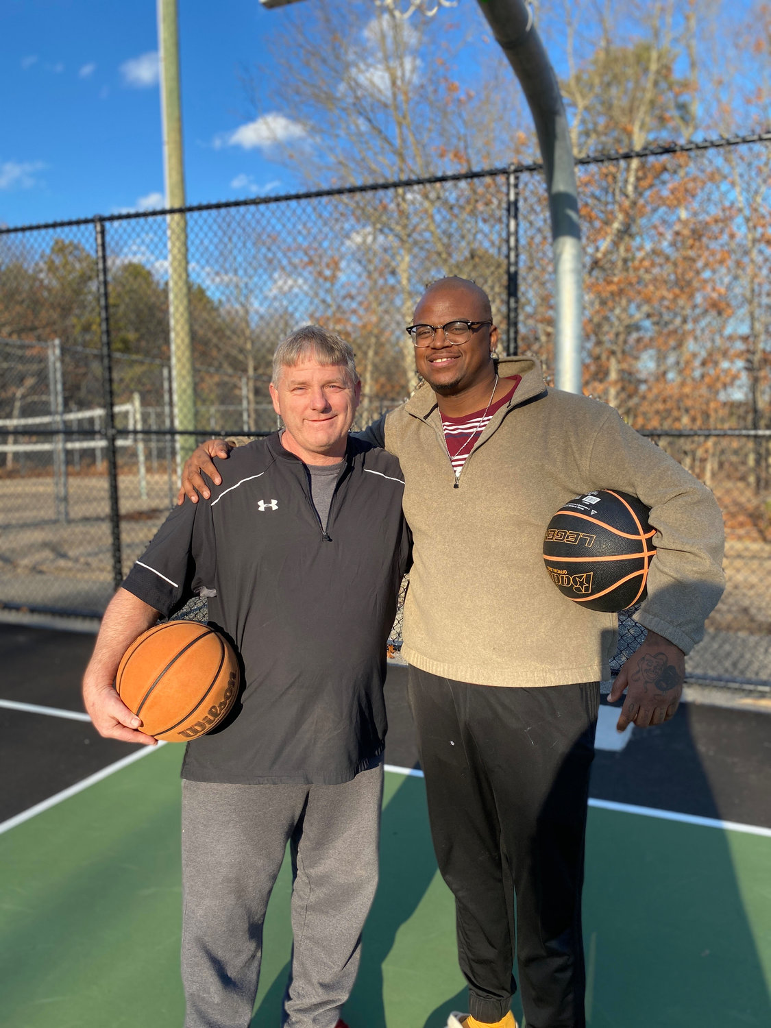Friends Ron Turner and Jordan Walker enjoy the refurbished basketball court on a recent afternoon.